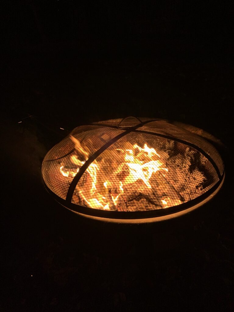 A small outdoor fire in a covered fire pit.