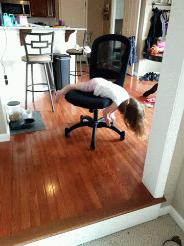 GIF of a kid lying across an office chair idly spinning around.
