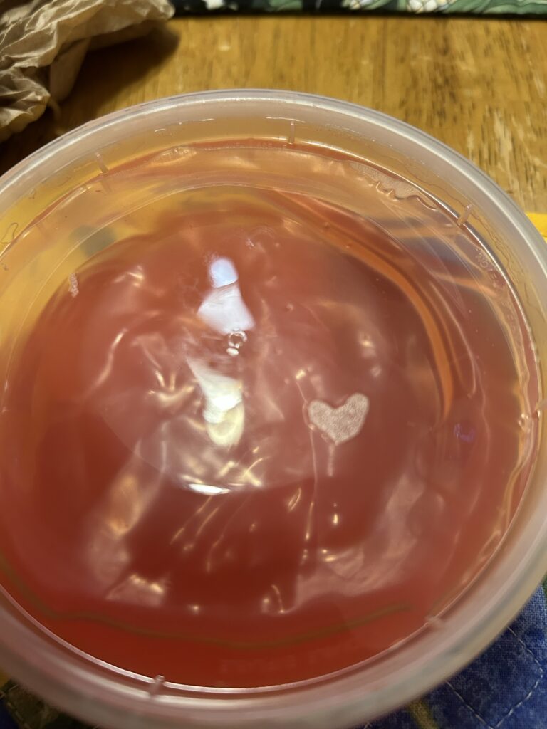 A photo of a container of cherry sauce with a heat made of steam visible on the right side of the cover.